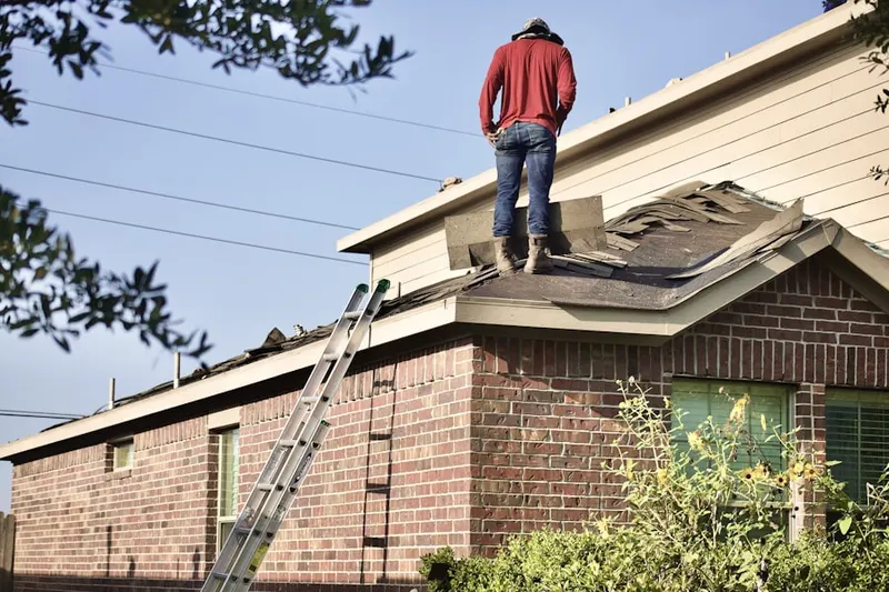 Professional roofer working on a residential roof in Islip Terrace